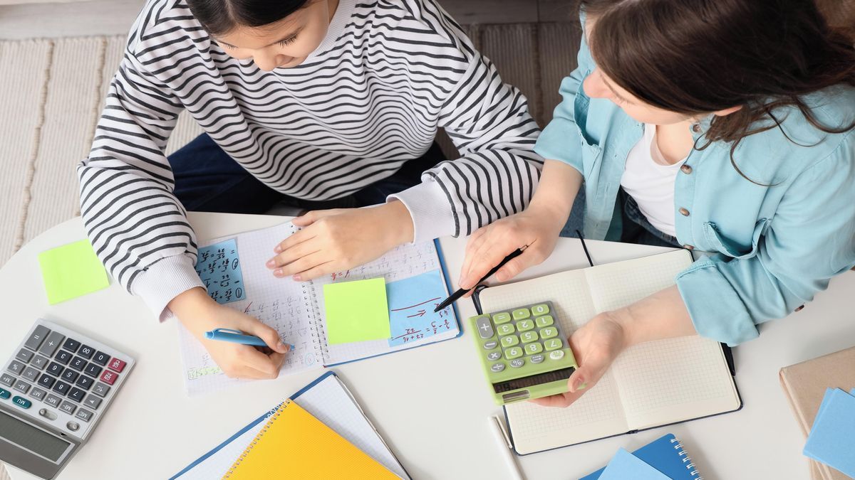 Doučování matematiky u stolu s poznámkami a kalkulačkou